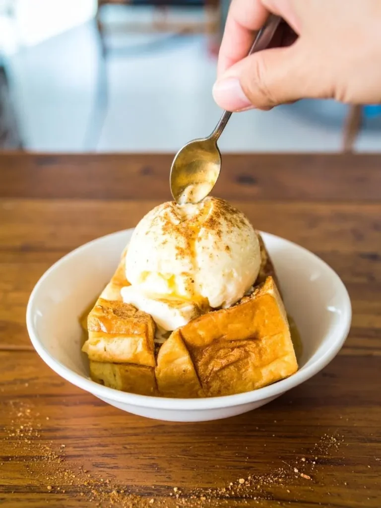 Step-by-step process showing how to dip bread in egg mixture for French Toast Waffle Hybrid
